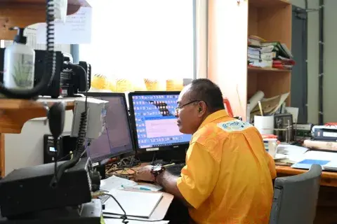 A meteorological services employee at his duty station in Tonga